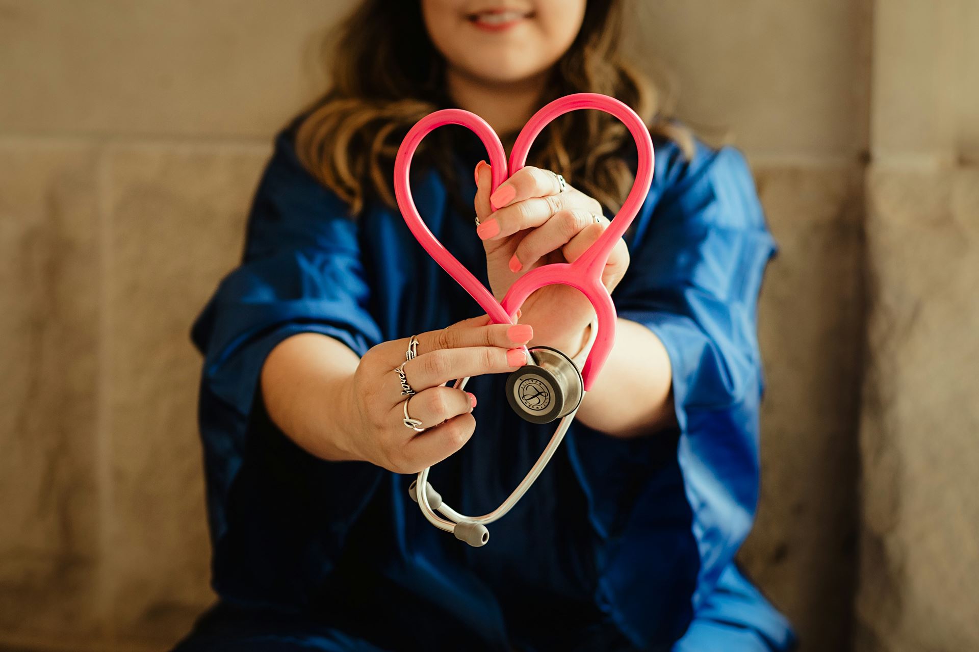 lady holding stethoscope in shape of a heart